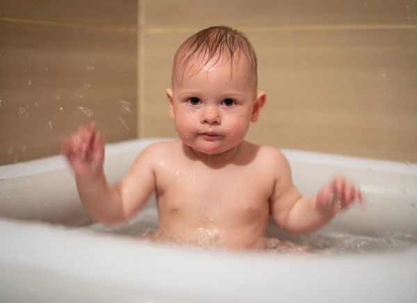 Baby sitting in bath with no bubbles