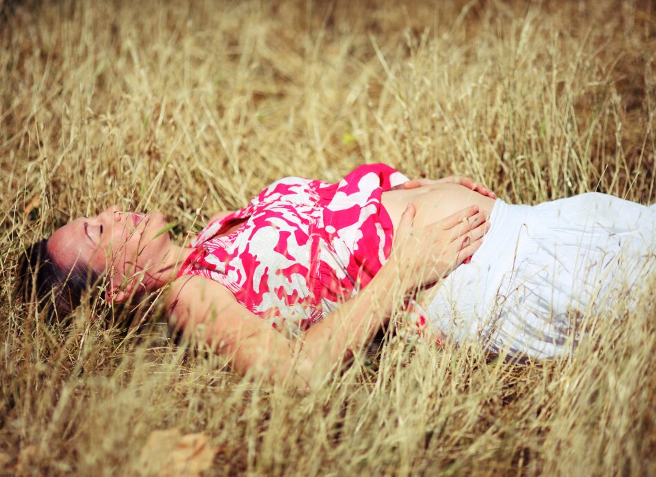 Pregnant woman lying in field