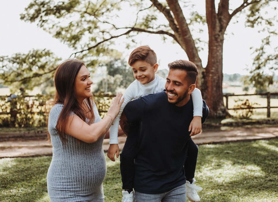 Pregnant woman with partner and child outdoors