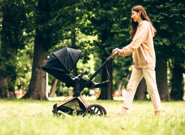 Woman walking in park with baby in stroller