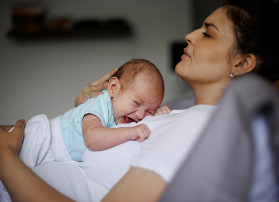 Worried parent holding crying baby