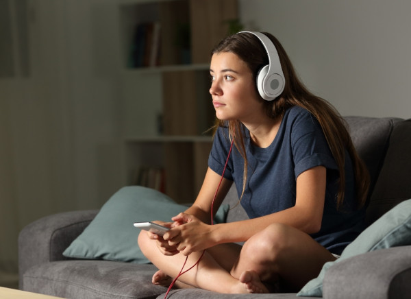 Young person listening to music through headphones