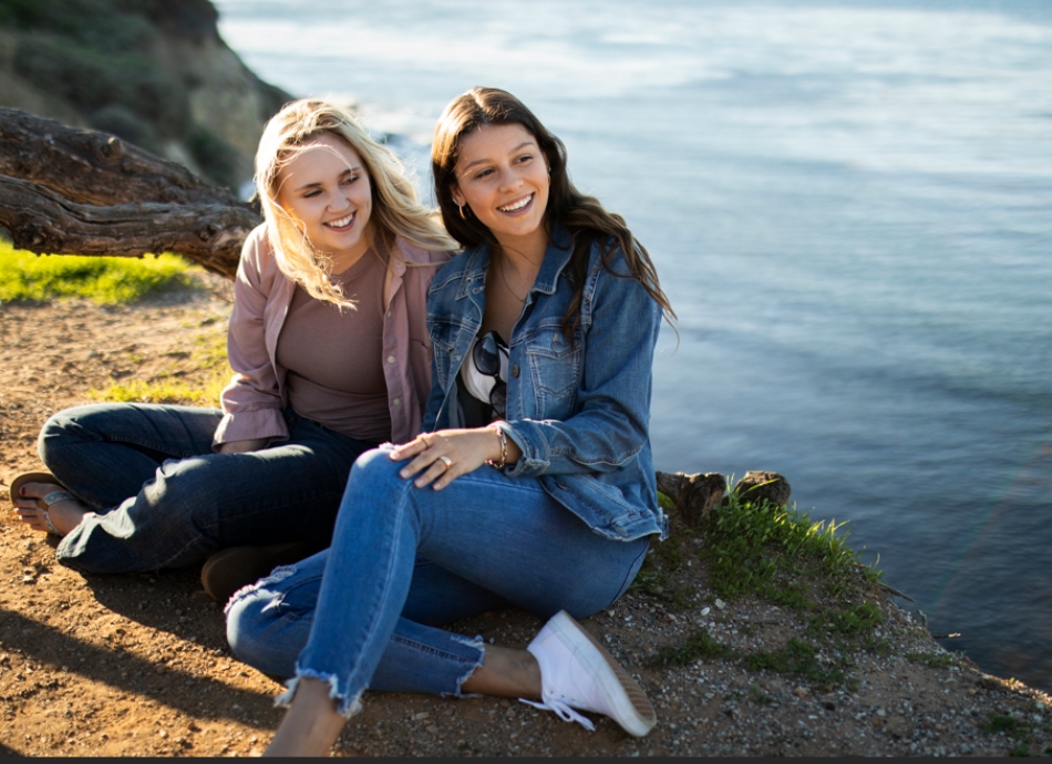 Young women on cliff top above sea 