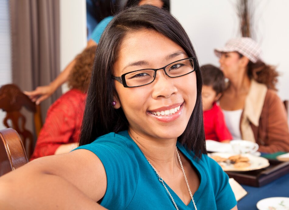 Smiling young woman at a social gathering with friends