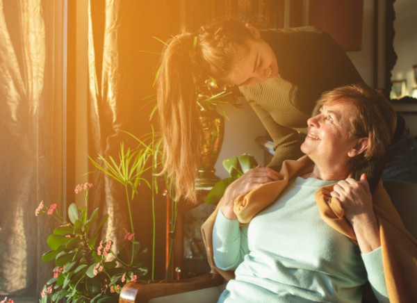 woman being hugged by younger woman or daughter as light streams in