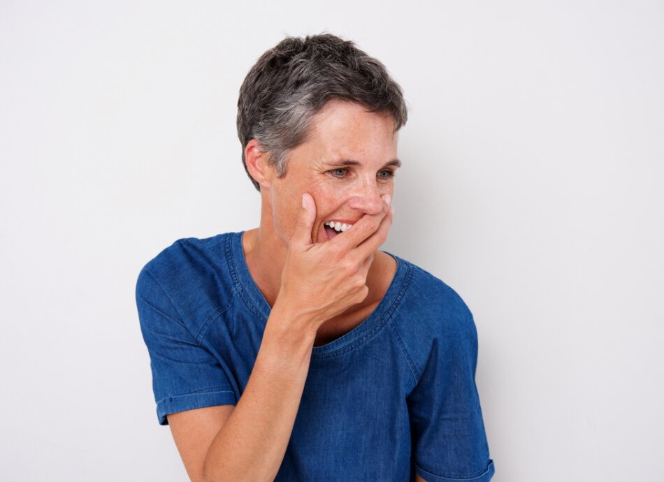 Woman amused hand over mouth canva 950x690