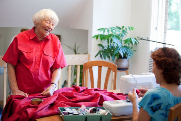 Senior women sewing together around table 