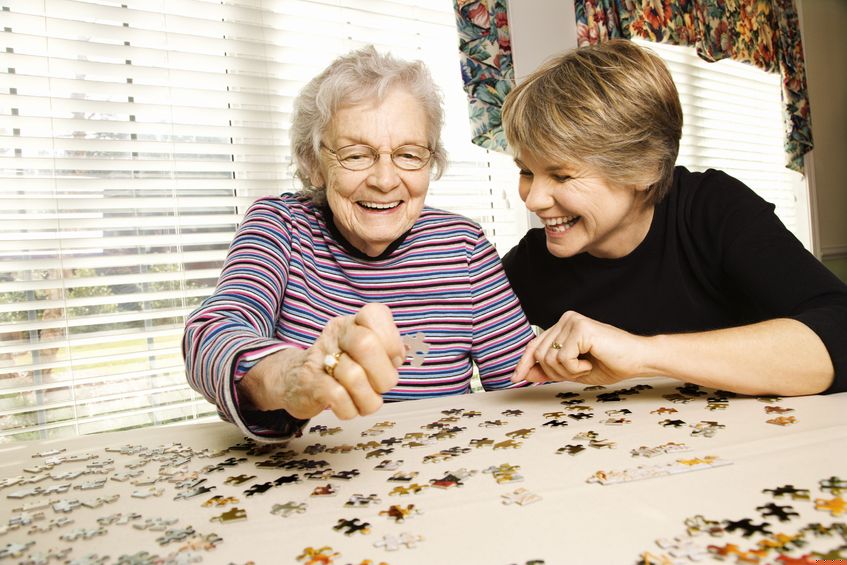 Older woman doing jigsaw with younger woman