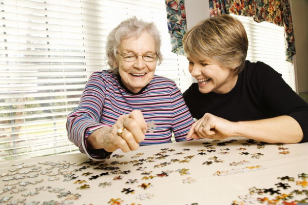 Women doing a jigsaw puzzle and laughing