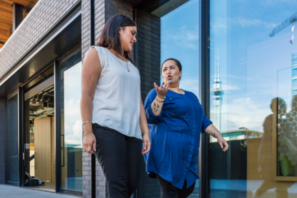 Two Māori women walking and talking in the city