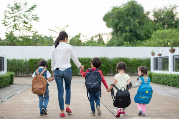 Parent walking 3 children into school