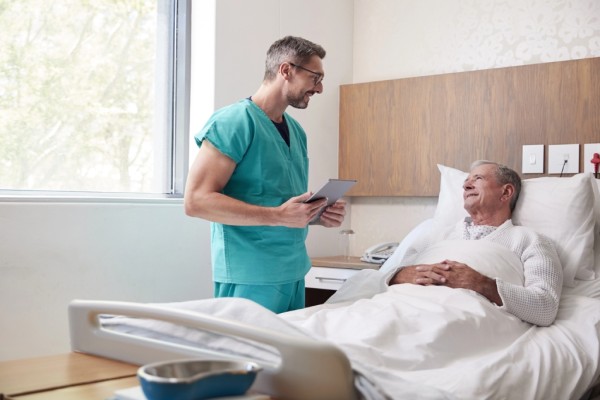 Doctor visiting male patient in hospital