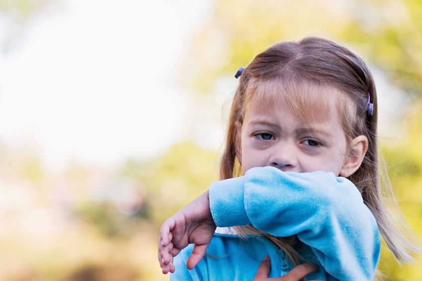 Child coughing into elbow