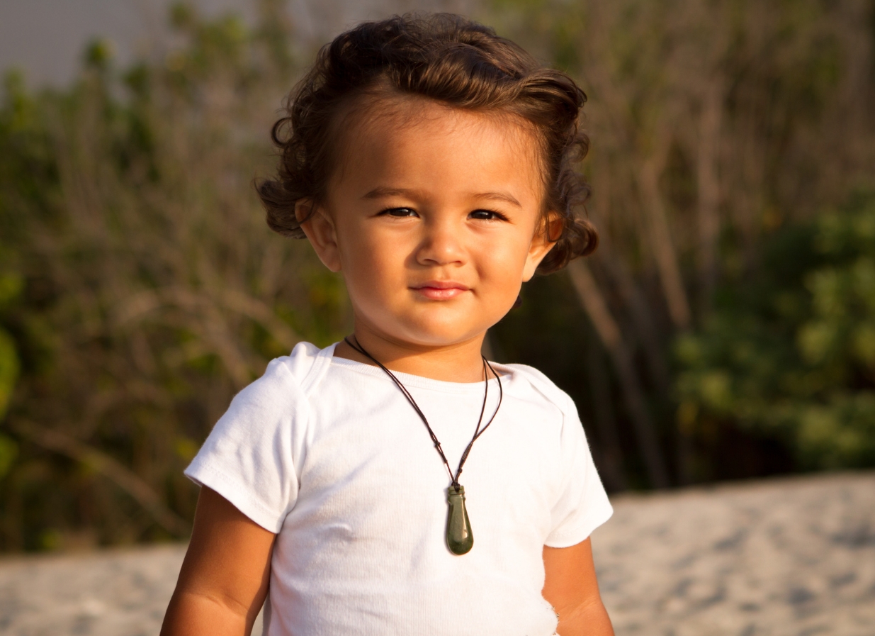 Māori toddler outside with pounamu necklace 