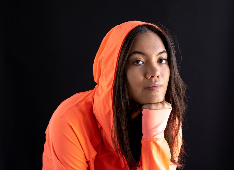 Young wahine Māori woman wearing orange hoody