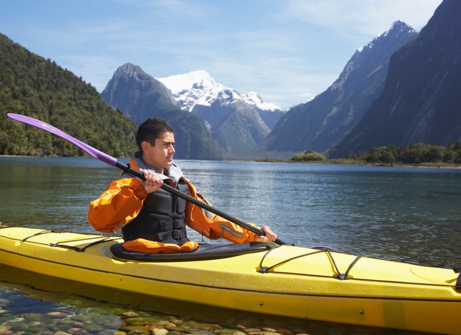Man kayaking on NZ lake or fiord