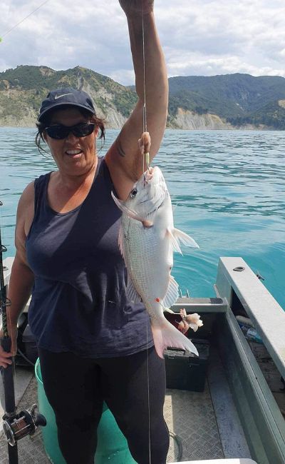 A delighted Frances King holds up a large fish