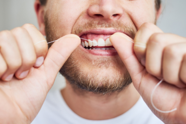 Man flossing his front teeth